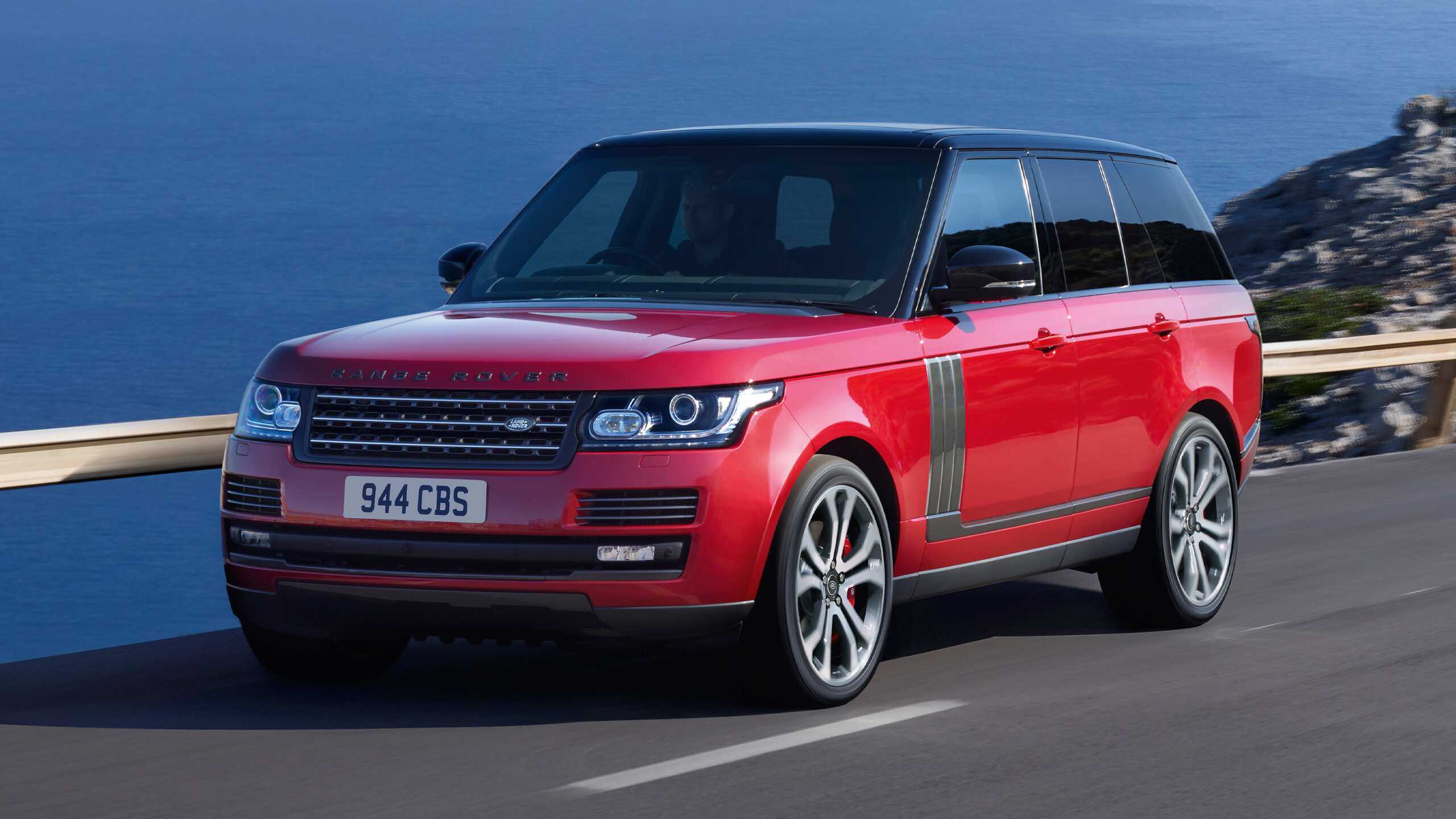 Range Rover running on Asphalt road beside the sea